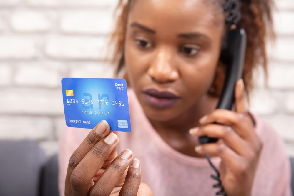 268419304_woman looking at credit card on phone scam-min.jpeg