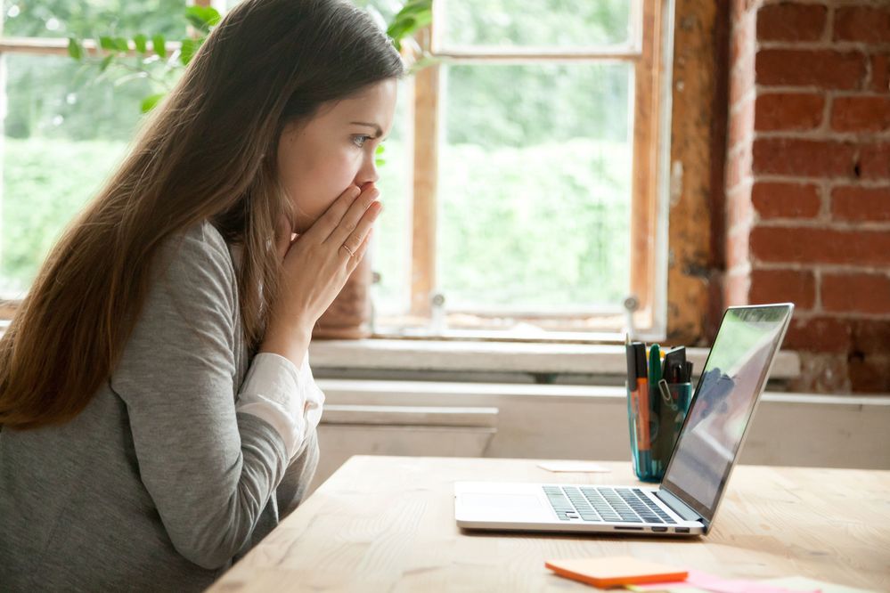 Lady looking at laptop in distress