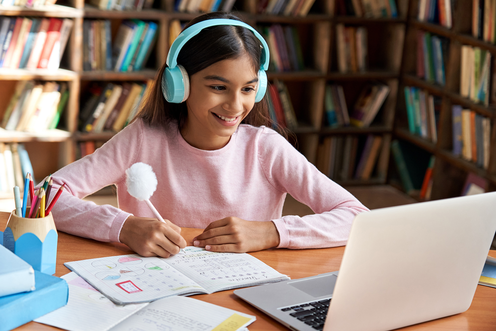 Girl wearing headphones sat with laptop