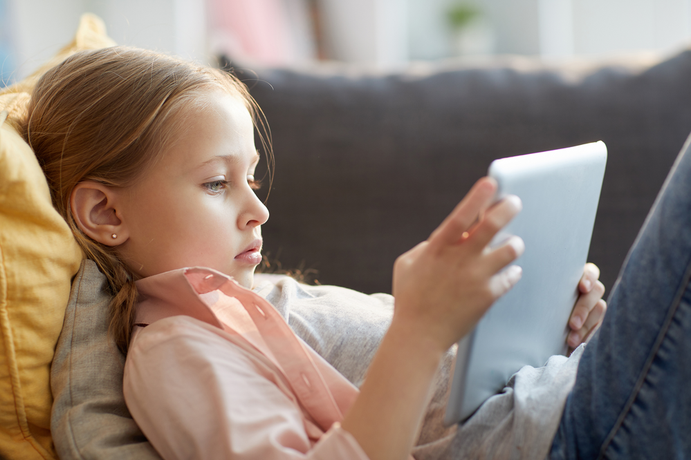 Girl with tablet on sofa