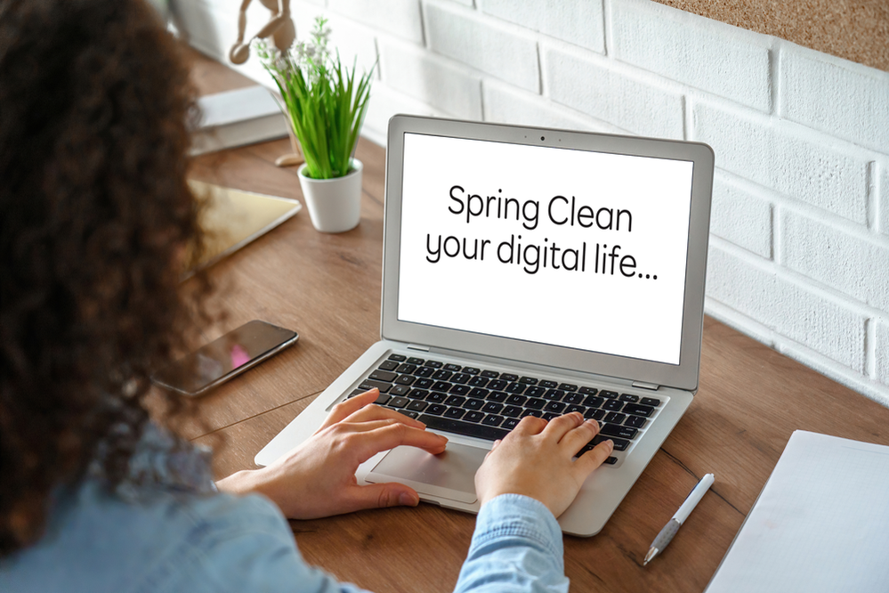 person with laptop with spring clean your digital life displayed on screen