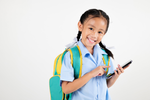 school child with back pack and mobile device